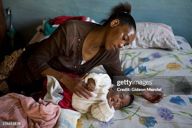 Ntsiuoa Ralefifi soothes her eight month old baby girl, Nthatisi Nkaota to sleep at her home in Harom Hapi. Ntsiuoa found out that she is HIV...