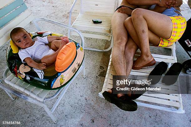 baby on lawn chair near parents in acapulco - acapulco chair stockfoto's en -beelden