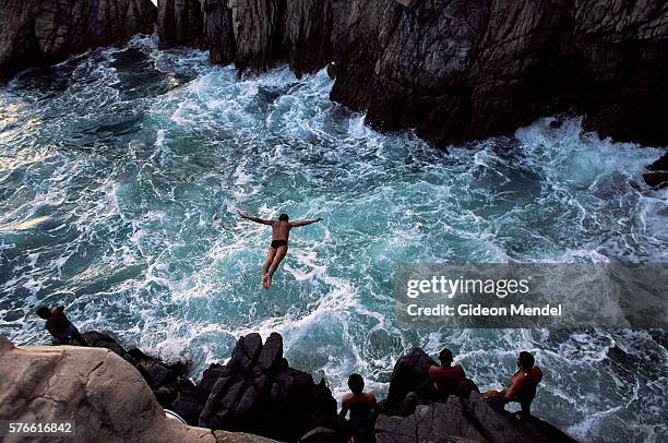 cliff divers at la quebrada - klippenspringen stock-fotos und bilder