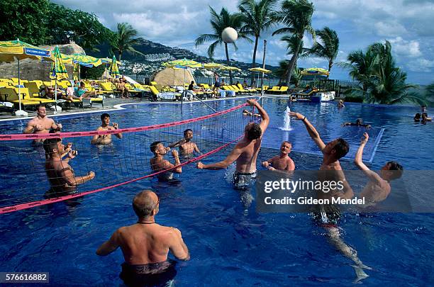 men playing swimming pool volleyball - acapulco chair stockfoto's en -beelden