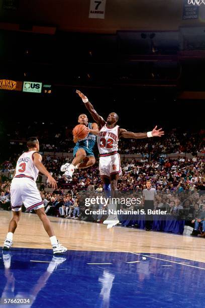 Tyrone "Mugsy" Bogues of the Charlotte Hornets goes up for a shot against Xavier McDaniel of the New York Knicks during a game circa 1991 at Madison...