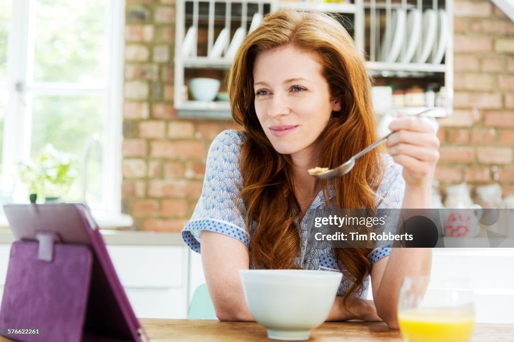Woman looking at tablet at breakfast