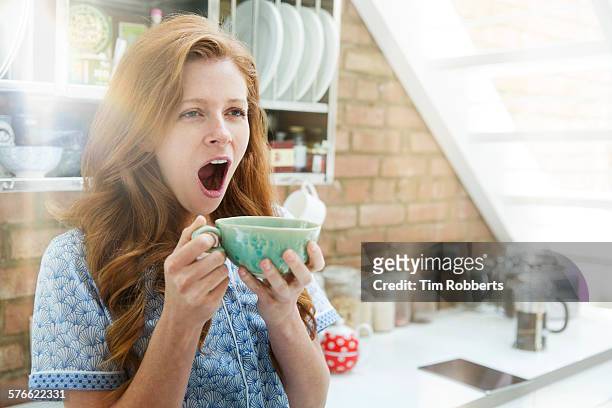 woman yawning with coffee - yawning woman stockfoto's en -beelden
