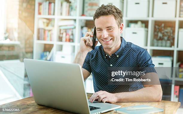 man using laptop and smartphone - short sleeved stock pictures, royalty-free photos & images