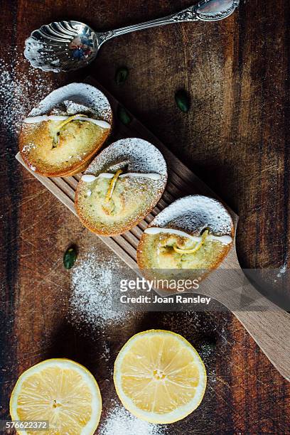 lemon and pistachio financiers - zitronentorte stock-fotos und bilder