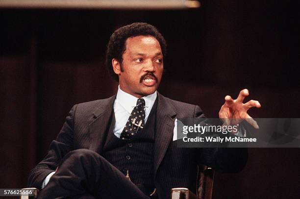 Presidential candidate Jesse Jackson gestures as he speaks at a debate with fellow candidates Gary Hart and Walter Mondale.