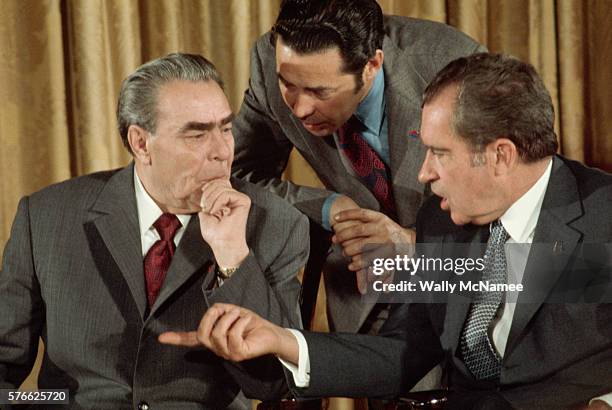 President Richard Nixon speaks through an interpreter to Soviet president Leonid Brezhnev as the two leaders prepare to sign a treaty during...