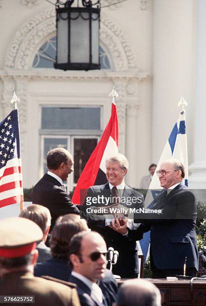 Egyptian president Anwar el-Sadat, US President Jimmy Carter, and Israeli Prime Minister Menachem Begin share a three-way handshake after signing an...