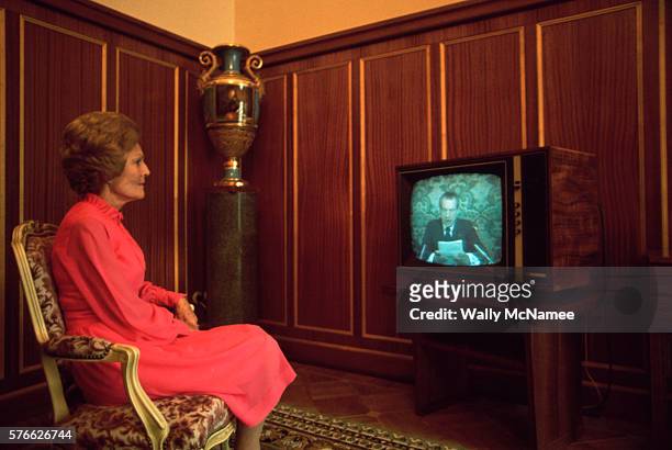 First Lady Pat Nixon watches as her husband, president Richard Nixon, gives a televised speech.