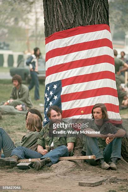 Vietnam veterans participating in the "May Day" demonstration sit in their campground in D.C. Below an upside-down American flag--a distress signal....