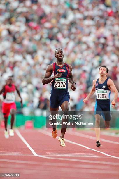 Sprinter Michael Johnson wears his gold shoes as he takes first place in a 400 meter qualifying heat at Atlanta's Olympic Stadium during the 1996...