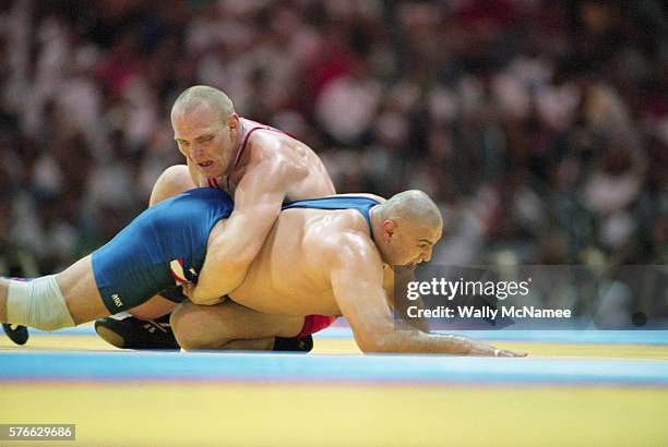 Alexander Karelin of Russia holds down Matt Ghafarri of the USA as they compete for the gold medal in the super heavyweight Greco-Roman wrestling...