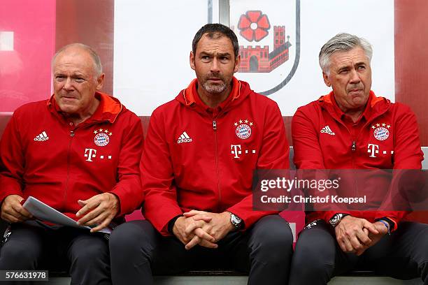Assistant coach Hermann Gerland, assistant coach Paul Clement and head coach Carlo Ancelotti of Bayern Muenchen sit on the bench during the friendly...