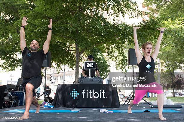 Fitbit Local Ambassadors Jeremy Walton and Jenny Finkel lead participants in a yoga workout during the launch of Fitbit Local Free Community Workouts...