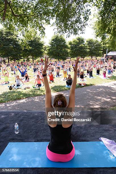 Fitbit Local Ambassador Jenny Finkel leads participants in a yoga workout during the launch of Fitbit Local Free Community Workouts In Chicago at...