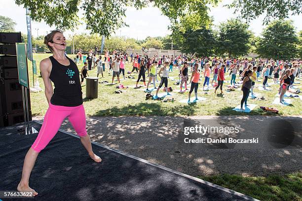 Fitbit Local Ambassador Jenny Finkel leads participants in a yoga workout during the launch of Fitbit Local Free Community Workouts In Chicago at...