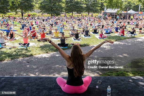 Fitbit Local Ambassador Jenny Finkel leads participants in a yoga workout during the launch of Fitbit Local Free Community Workouts In Chicago at...