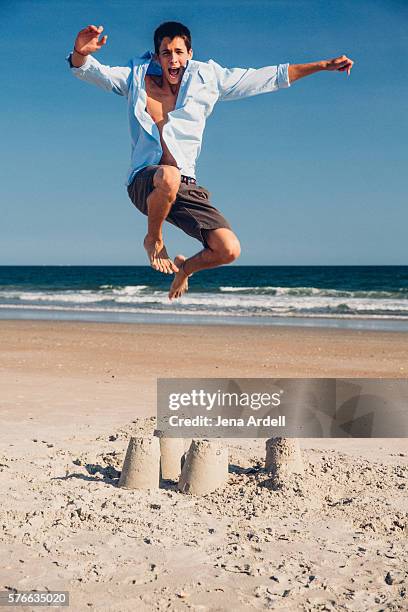 man jumping on sand castle - like a child in a sweet shop stock pictures, royalty-free photos & images