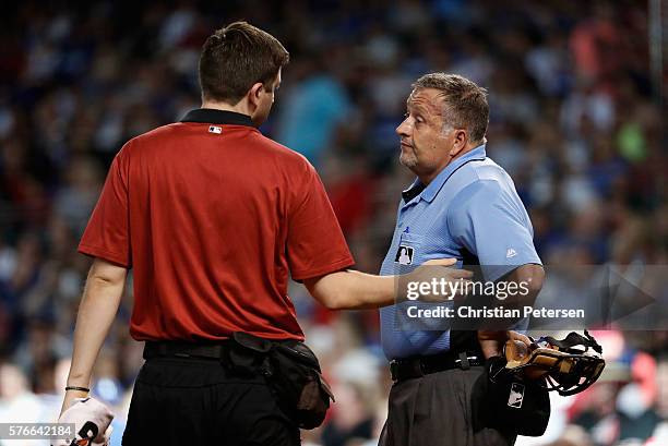 Home plate umpire Dale Scott is looked at by a Arizona Diamondbacks team trainer after being hit by a foul ball during the first inning of the MLB...