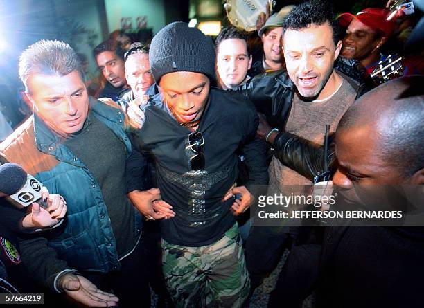 Barcelona's footballer and member of the Brazilian national team Ronaldinho Gaucho is surrounded by security personnel upon his arrival early 20 May,...