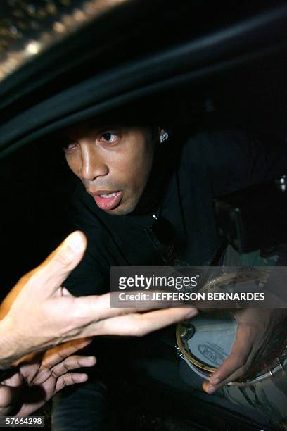 Barcelona's footballer and member of the Brazilian national team Ronaldinho Gaucho receives a tambourine from a fan upon his arrival early 20 May,...