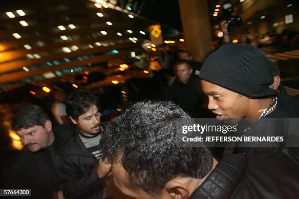 Barcelona's footballer and member of the Brazilian national team Ronaldinho Gaucho , surrounded by security personnel, jokes arrives val early 20...