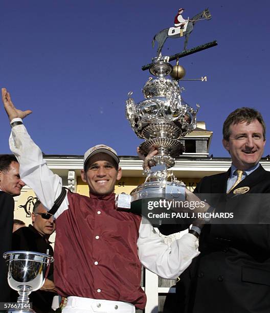 Baltimore, UNITED STATES: Bernardini jockey Javier Castellano and a representative from Darley Stabes hold the Woodlawn Vase in the winner's circle...