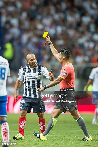 Walter Gargano of Monterrey argues with referee Adonai Escobedo as he shows a yellow card during the 1st round match between Monterrey and Puebla as...