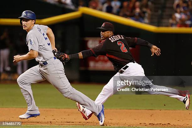 Corey Seager of the Los Angeles Dodgers is tagged out in a run down by infielder Jean Segura of the Arizona Diamondbacks during the MLB game at Chase...