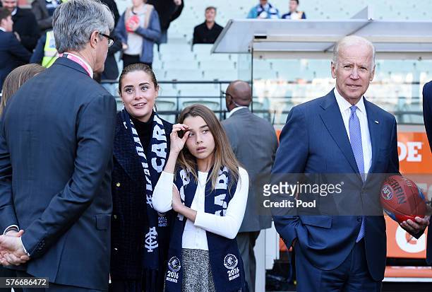 Vice-President Joe Biden holds an AFL football while his granddaughters Natalie and Naomi wear Carlton scarves before the round 17 AFL match between...