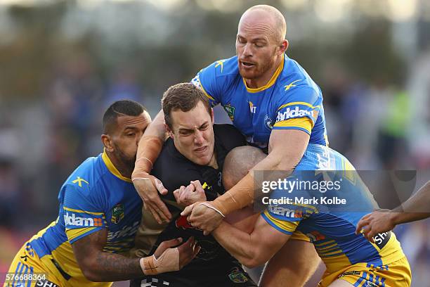 Manu Ma'u, Beau Scott and Jeff Robson of the Eels tackle Isaah Yeo of the Panthers during the round 19 NRL match between the Penrith Panthers and the...