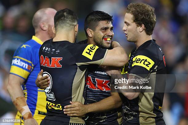Josh Mansour, Tyrone Peachey and Matt Moylan of the Panthers celebrate Tyrone Peachey scoring a try during the round 19 NRL match between the Penrith...
