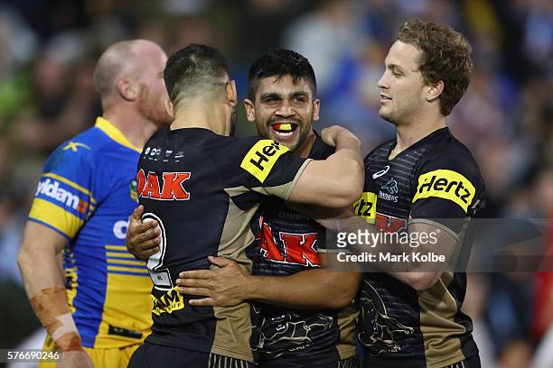 Josh Mansour, Tyrone Peachey and Matt Moylan of the Panthers celebrate Tyrone Peachey scoring a try during the round 19 NRL match between the Penrith...