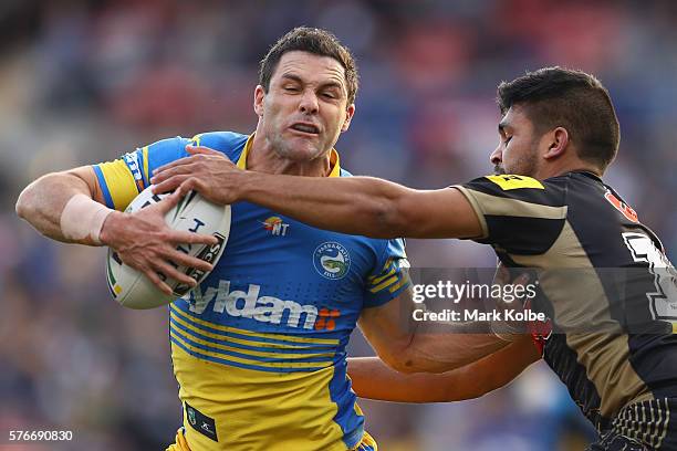 Michael Gordon of the Eels is tackled by Tyrone Peachey of the Panthers during the round 19 NRL match between the Penrith Panthers and the Parramatta...