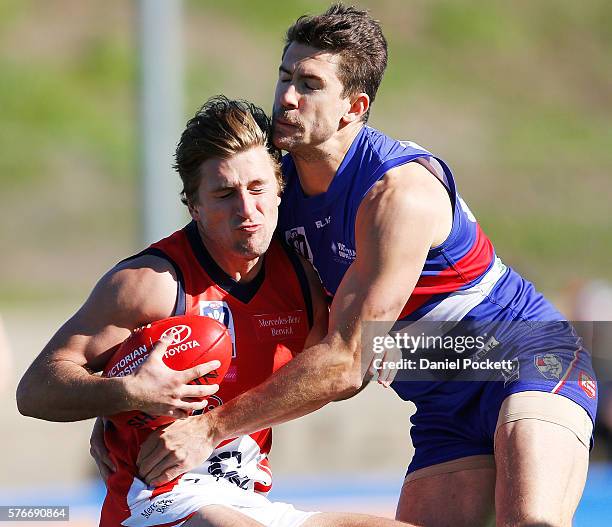 Viv Michie of the Scorpions is tackled by Jordan Russell of the Bulldogs during the round 15 VFL match between the Footscray Bulldogs and the Casey...