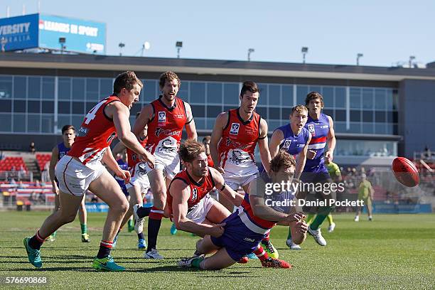 Gabriel Hamilton of the Bulldogs handballs the ball whilst being tackled by Matt Jones of the Scorpions during the round 15 VFL match between the...