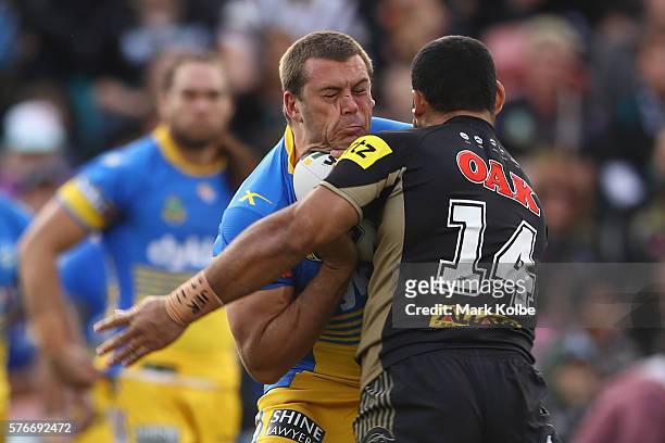 Danny Wicks of the Eels is tackled by Suaia Matagi of the Panthers during the round 19 NRL match between the Penrith Panthers and the Parramatta Eels...
