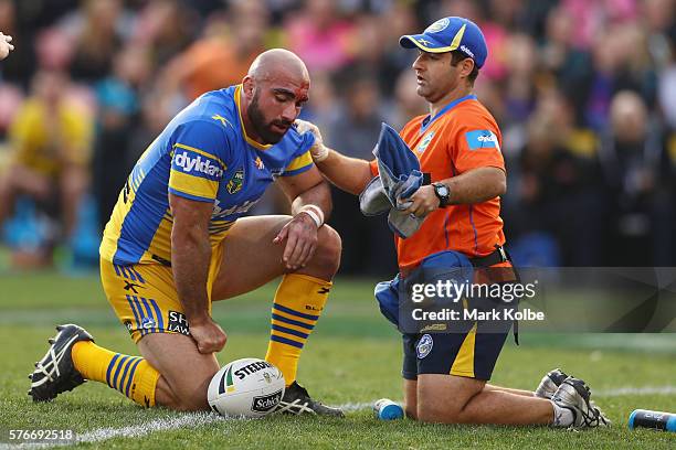 Tim Mannah of the Eels receives attention from the trainer during the round 19 NRL match between the Penrith Panthers and the Parramatta Eels at...