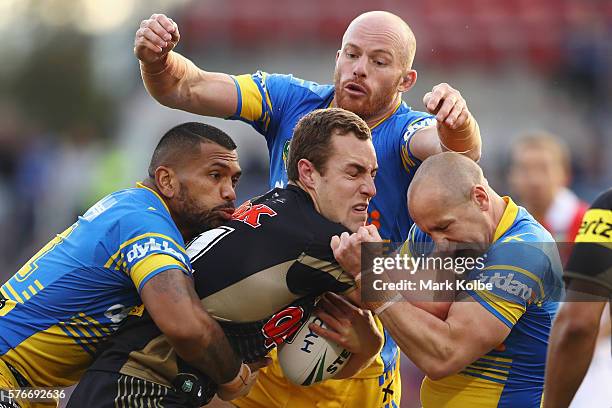 Manu Ma'u, Beau Scott and Jeff Robson of the Eels tackle Isaah Yeo of the Panthers during the round 19 NRL match between the Penrith Panthers and the...