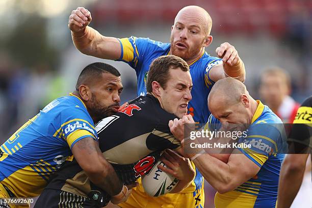 Manu Ma'u, Beau Scott and Jeff Robson of the Eels tackle Isaah Yeo of the Panthers during the round 19 NRL match between the Penrith Panthers and the...