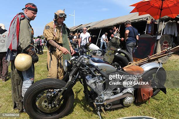 Two men look at motorcycles during the Wheels and Waves Motorcycle event in Biarritz on June 09, 2016. / AFP / IROZ GAIZKA / TO GO WITH AFP STORY BY...