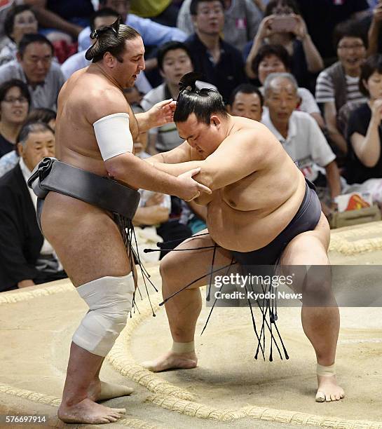 Japanese ozeki Kisenosato marches Georgian sekiwake Tochinoshin out of the ring on the seventh day of the Nagoya Grand Sumo Tournament at Aichi...