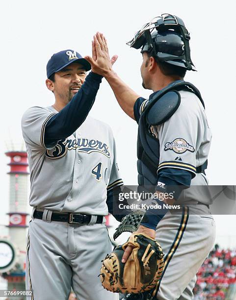 United States - Milwaukee Brewers reliever Takashi Saito gives a high-five to catcher Wil Nieves, after throwing a scoreless eighth inning during the...