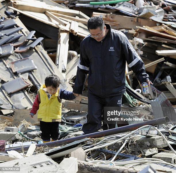 Japan - A man and his son visit the ruins of their home in Higashimatsushima, Miyagi Prefecture, on April 10 after the March 11 quake and tsunami.