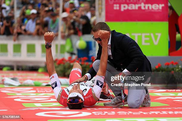 Jan Frodeno of Germany is greeted by Challenge Roth CEO Felix Walchshofer as he wins with a new world record time for long distance triathlon during...