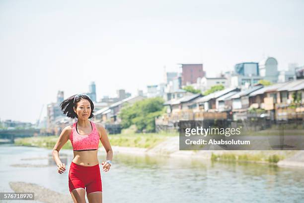 Japanese Woman Jogging On Banks Of Kamo River Kyoto Japan High-Res