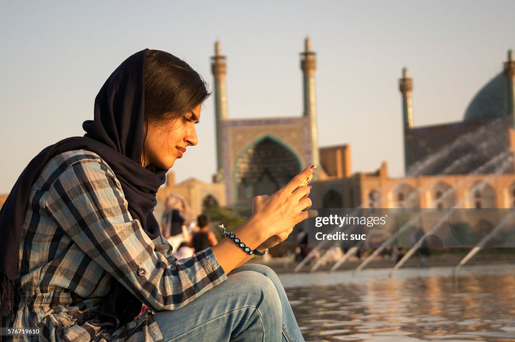 Mujer iraní revisando su teléfono móvil