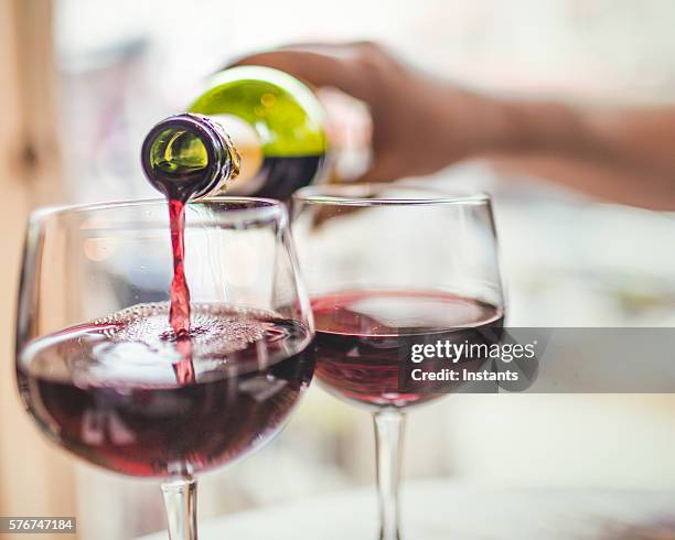 verter vino tinto en copas - vino tinto fotografías e imágenes de stock