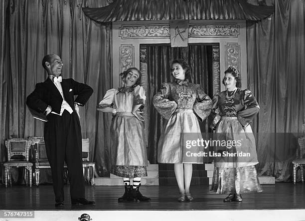 Hubert Tannar leads Princess Elizabeth and her sister Princess Margaret in a rehearsal for the pantomime 'Aladdin' at Windsor Castle, UK, December...