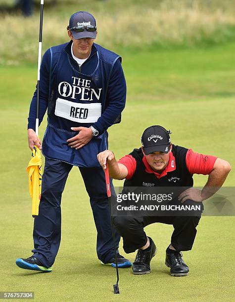 Golfer Patrick Reed and his his caddie Kessler Karain line up a putt on the 8th green during his final round on day four of the 2016 British Open...